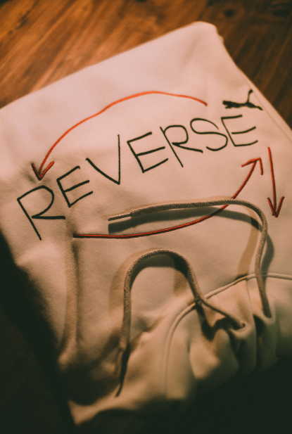 Lettering and line artwork across the front of a folded hoodie.