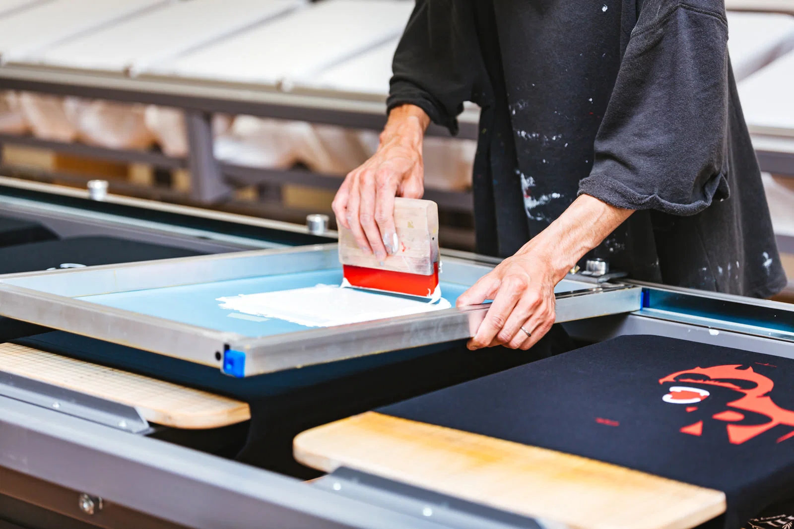 Screen printing a garment in a printing workshop.