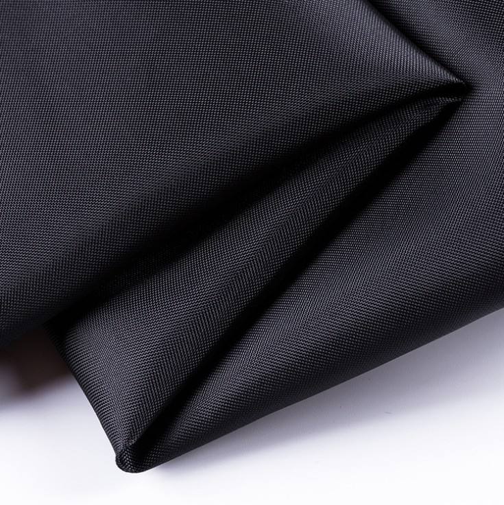 Black 210D polyester Oxford fabric folded in close-up, showing the fine technical weave without branding.
