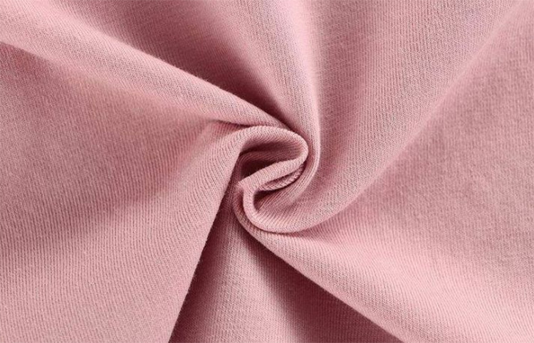 Soft pink modal knit folded into loose curves, showing the smooth fine-knit face and fluid drape associated with lightweight modal fabric.