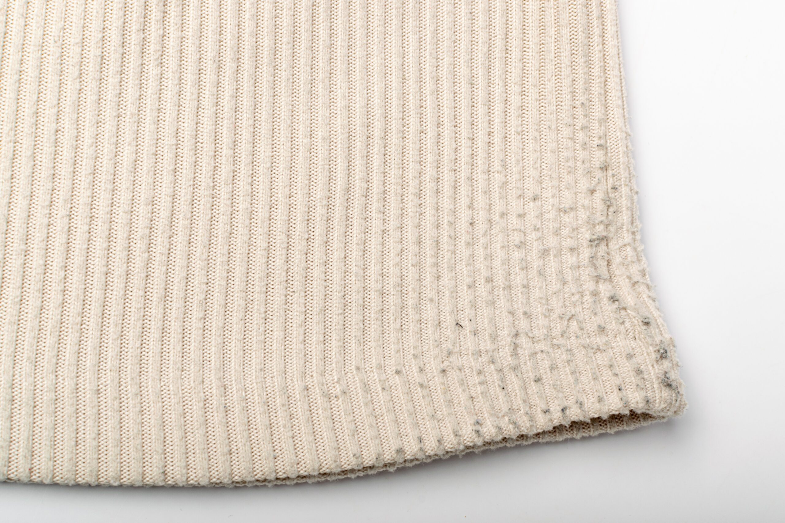 Small fiber pills visible on rib-knit fabric, illustrating the type of surface change discussed in pilling tests.