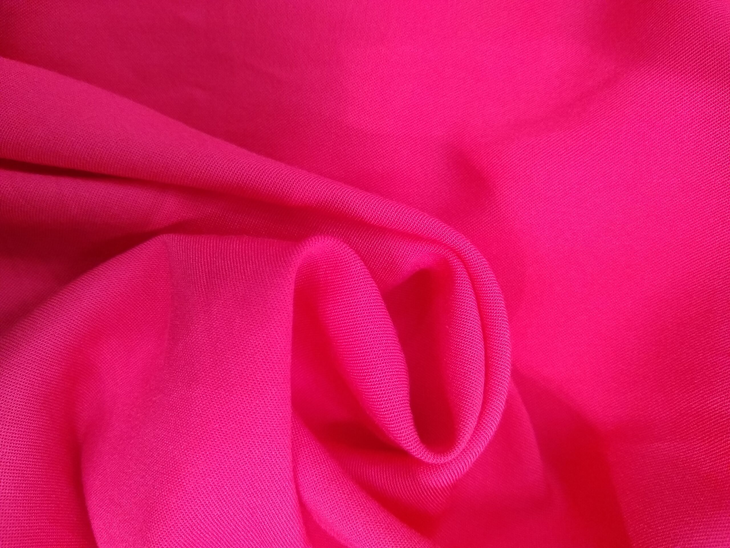 Pink rayon challis fabric arranged in soft folds