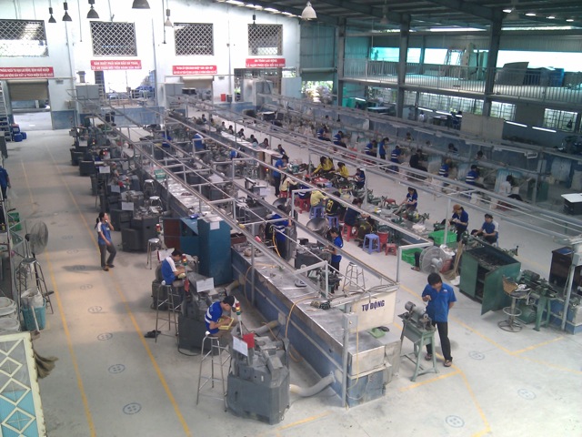 A shell-button factory floor in Vietnam with rows of workstations and machinery used to manufacture clothing buttons