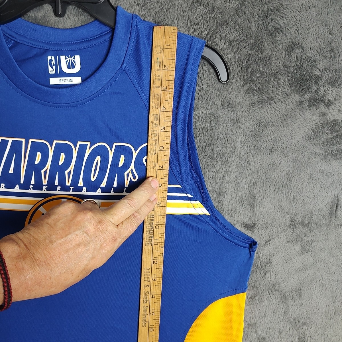 Basketball jersey armhole and body being measured with a ruler