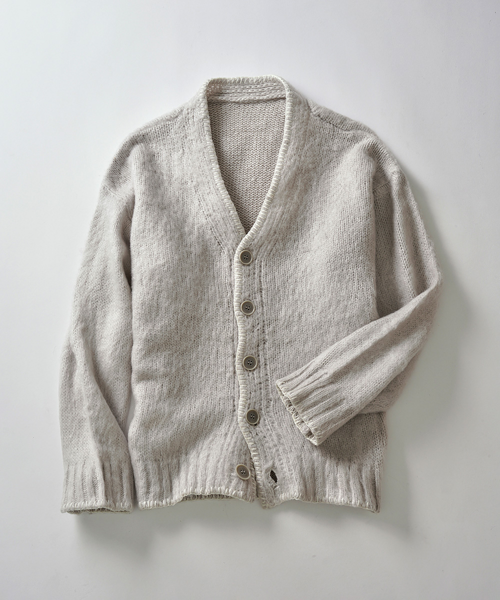 Beige knit cardigan laid flat with button front and ribbed edges