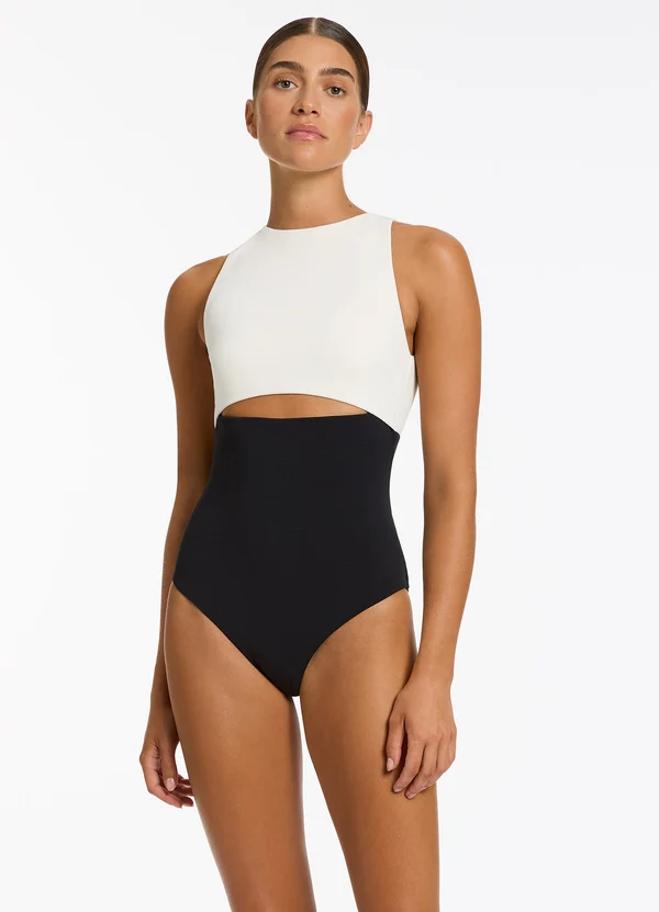 Black and cream one-piece swimsuit with a cutout beneath the bust
