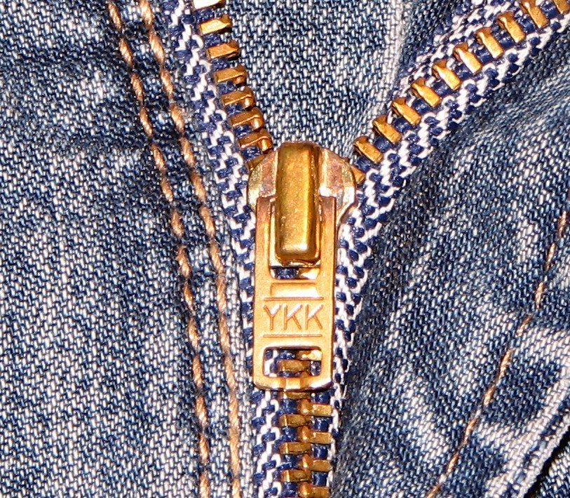 Close-up of a YKK zipper sewn into blue denim
