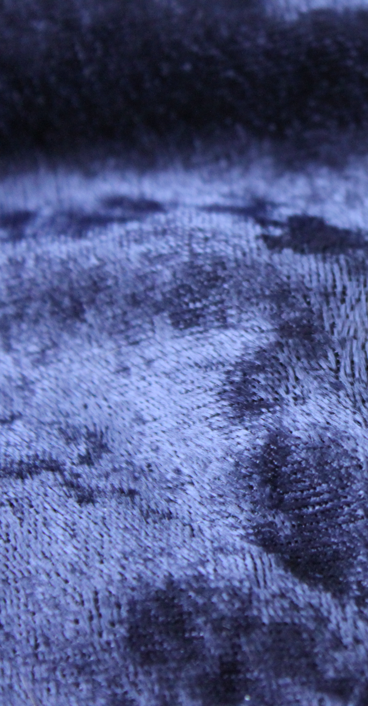 Close view of blue velvet showing the short raised pile across the fabric face.