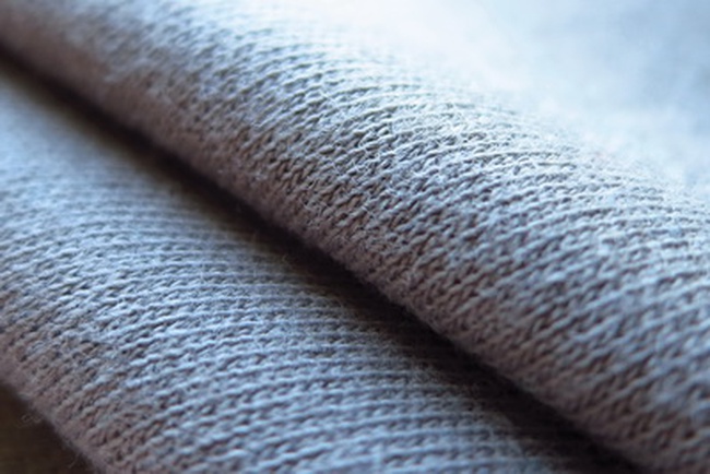 Close-up of cotton interlock knit showing the density and size of the knitted loops.