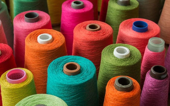 Colored yarn cones prepared for textile production