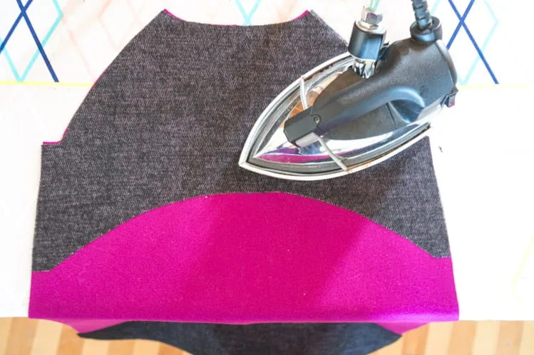 Construction reference: dark fusible interlining applied to a magenta coat panel with a steam iron