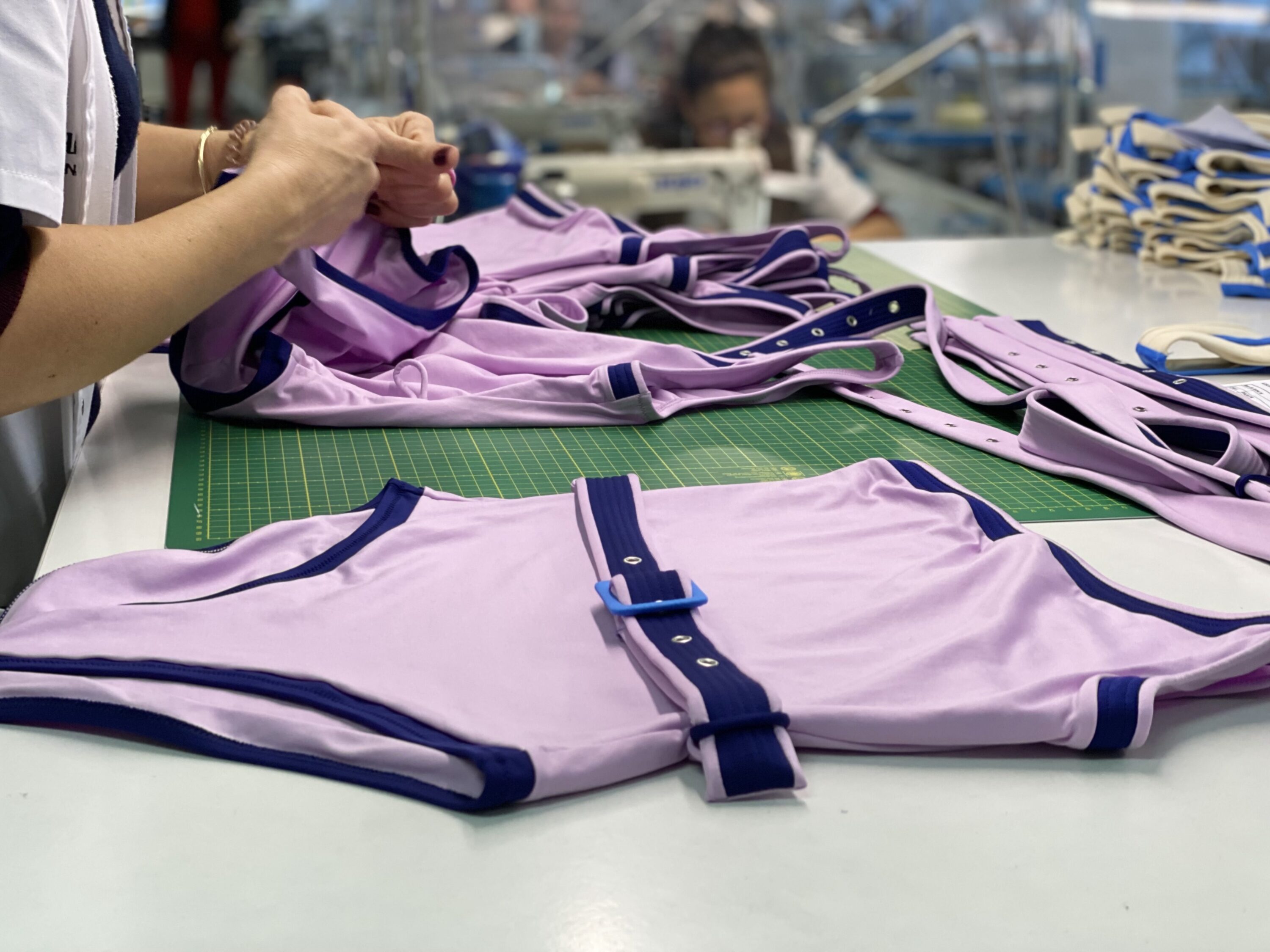 External production reference: finished one-piece swimsuits checked at a factory worktable