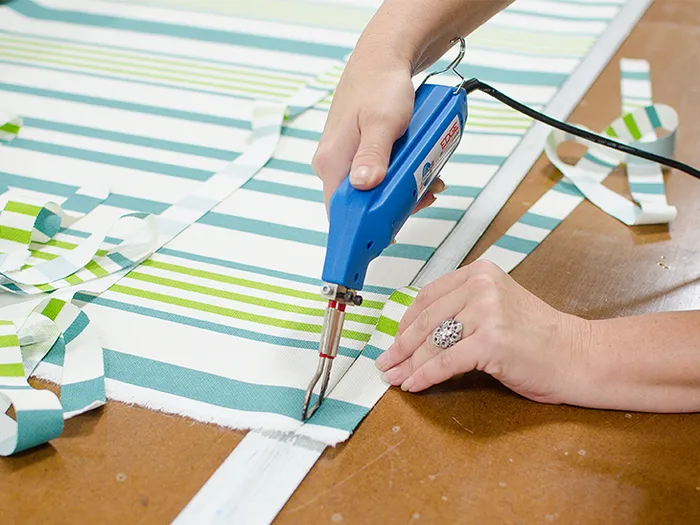 Fabric being cut with a hot knife