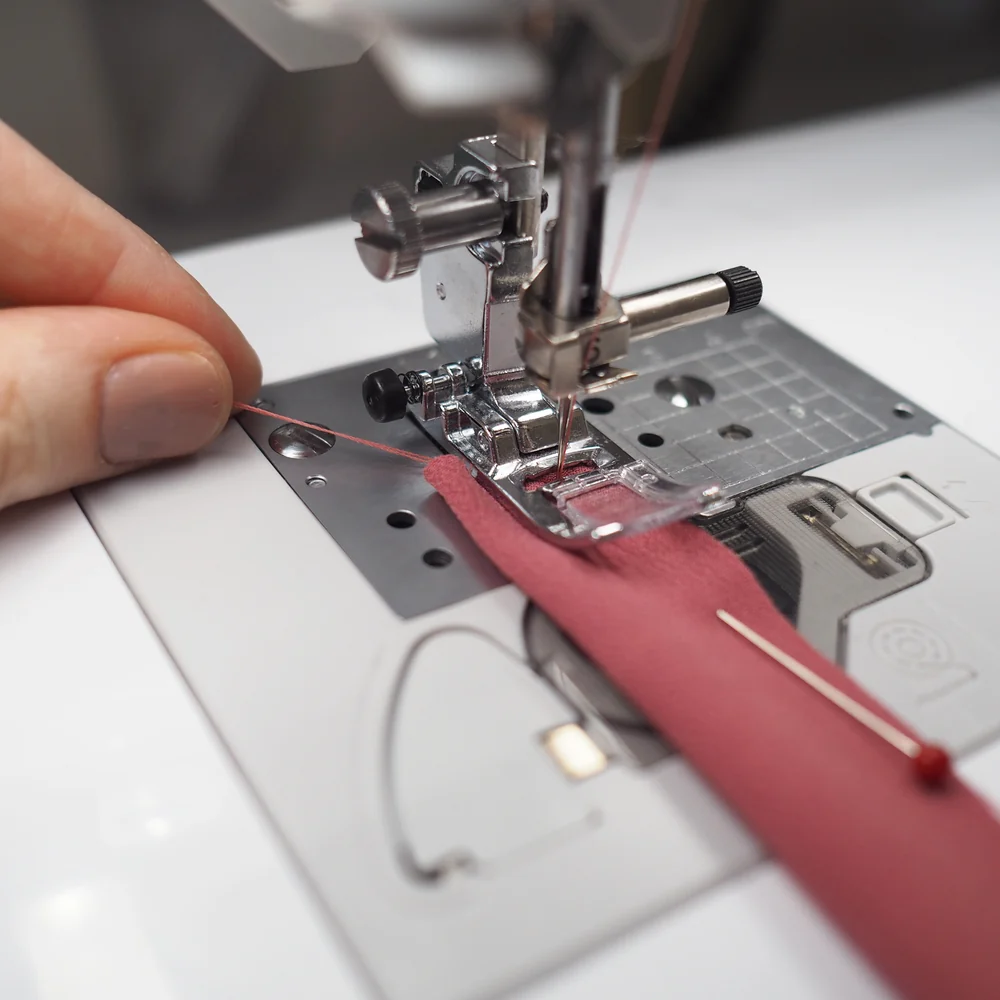 Fine silk fabric under a sewing machine presser foot