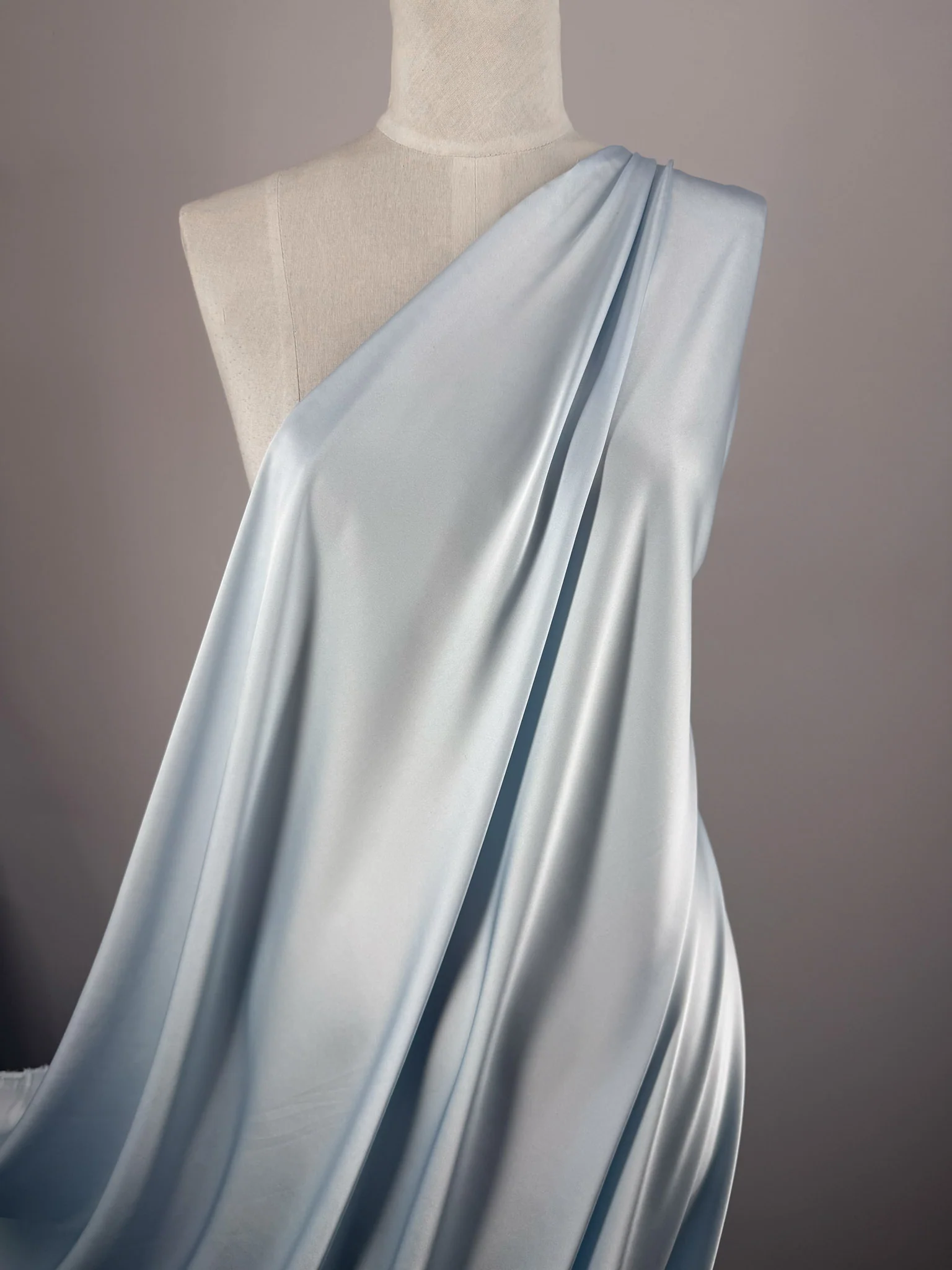 Fluid satin draped over a dress form