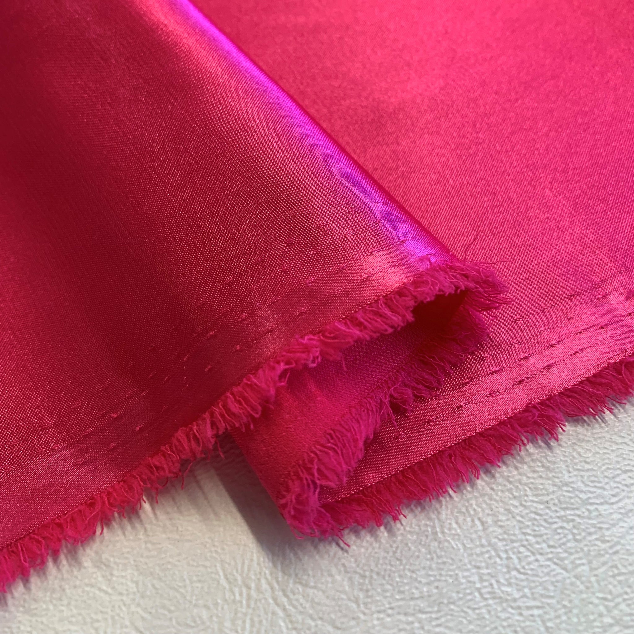 Frayed raw edge on satin fabric