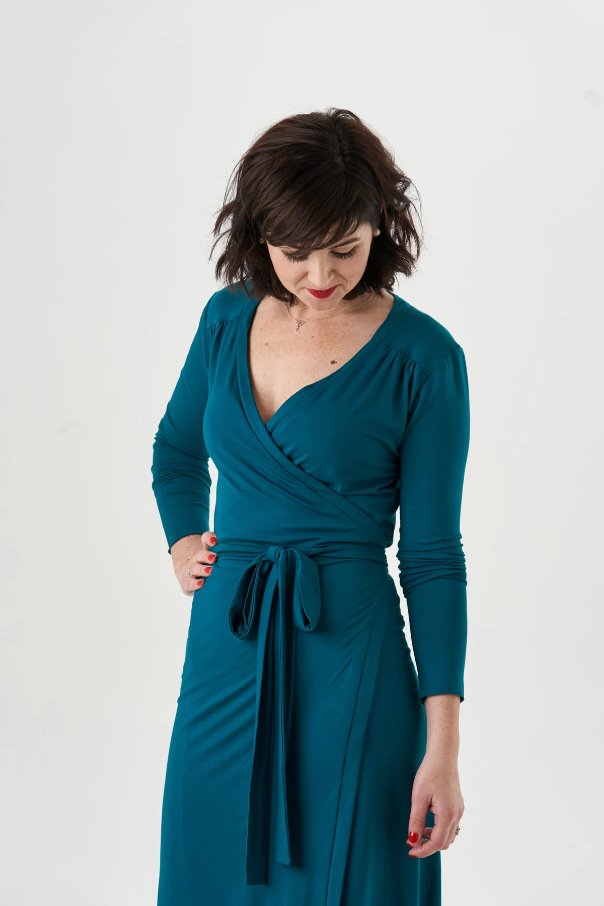 Garment reference: teal jersey wrap dress showing the overlapping neckline, gathered shoulder yokes and long waist ties