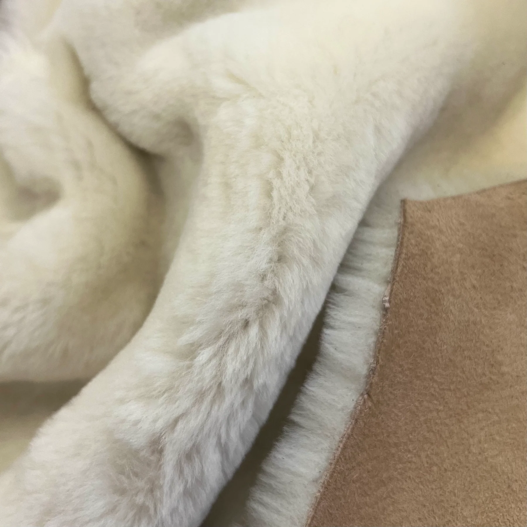 Genuine merino shearling folded to show natural wool attached directly to the hide backing.