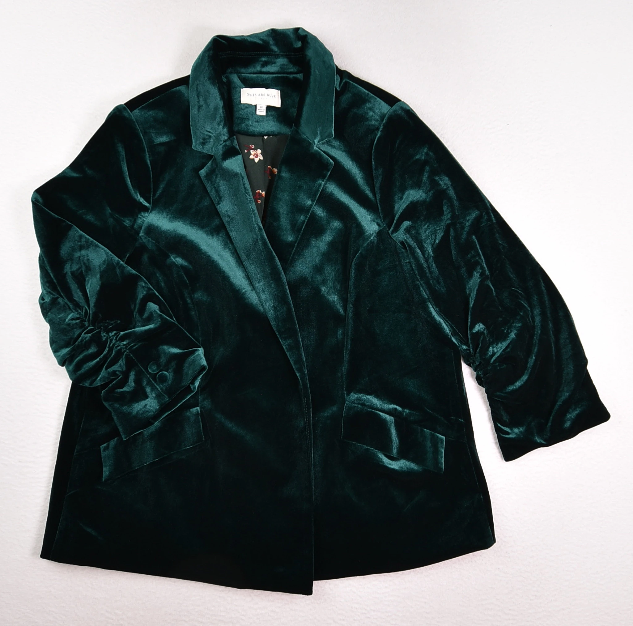 Green velvet blazer showing the pile across lapels, sleeves and structured panels.