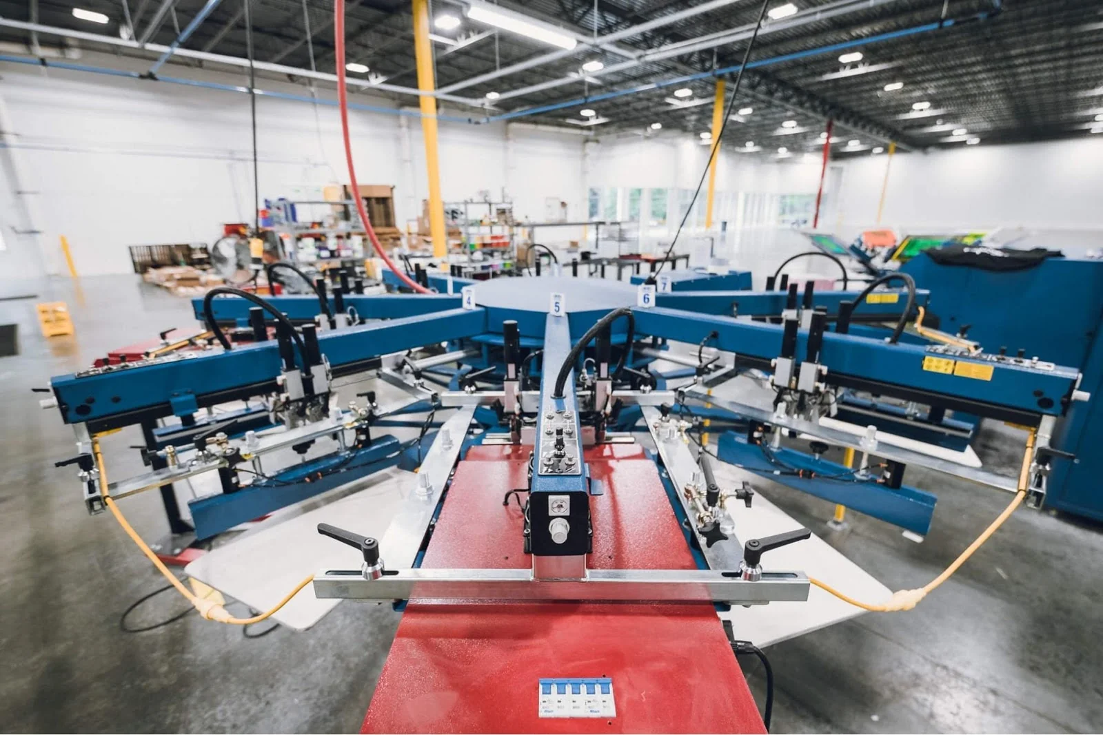 Industrial carousel screen printing machine with no operator in frame.