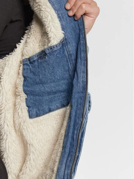 Interior of a denim jacket showing the volume taken up by a thick sherpa lining around the front opening and pocket.
