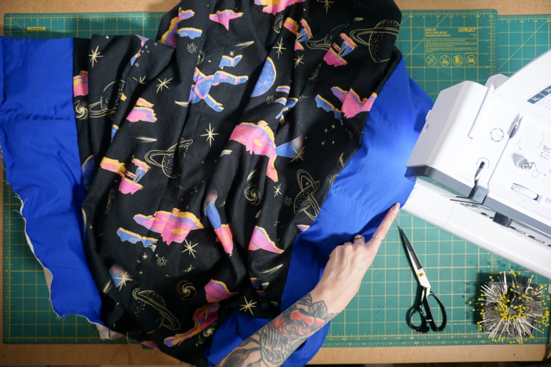 Lining construction reference: printed lining joined to the blue coat shell at a sewing machine