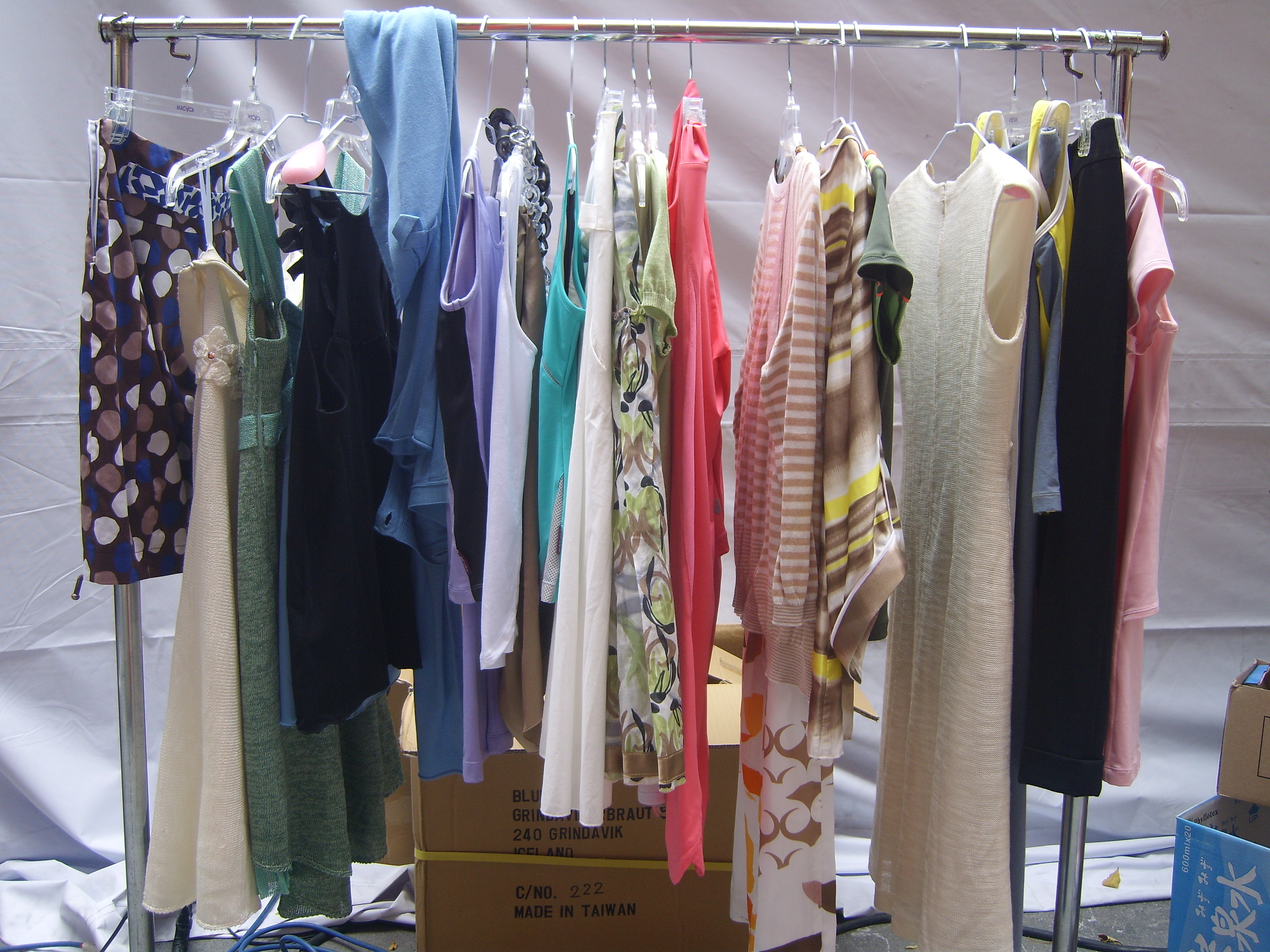 Multiple garments hanging on racks at a fashion trade event, matching the idea of finished styles already developed and waiting on a rail