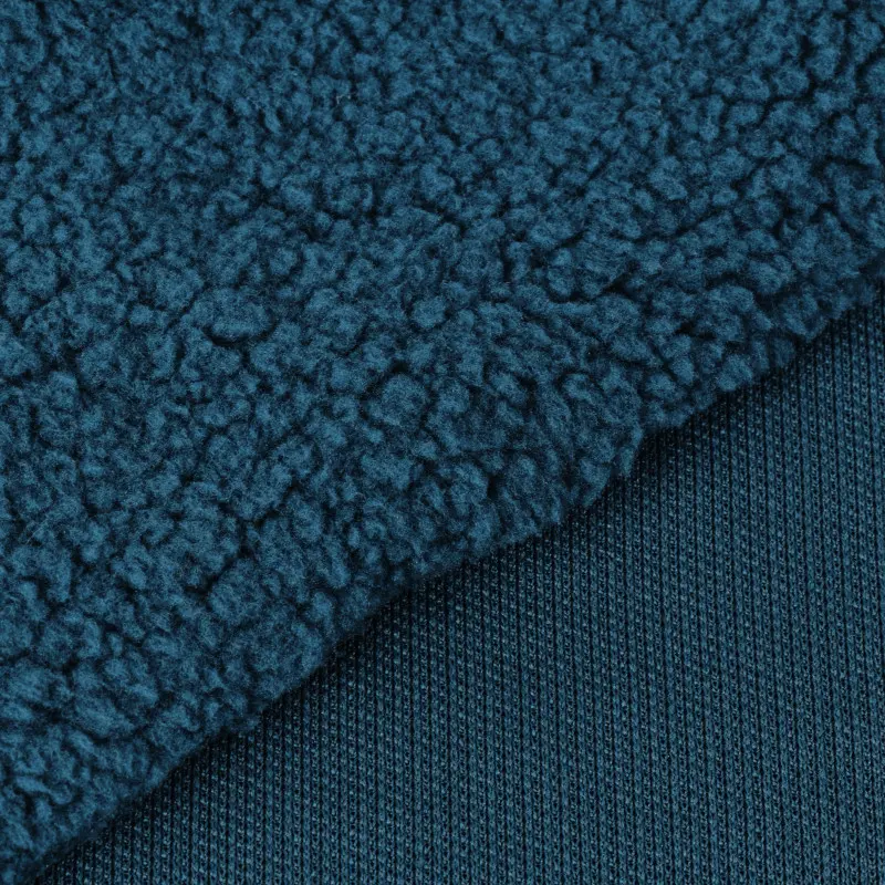 Navy sherpa fabric folded to reveal its curly pile and knitted reverse.