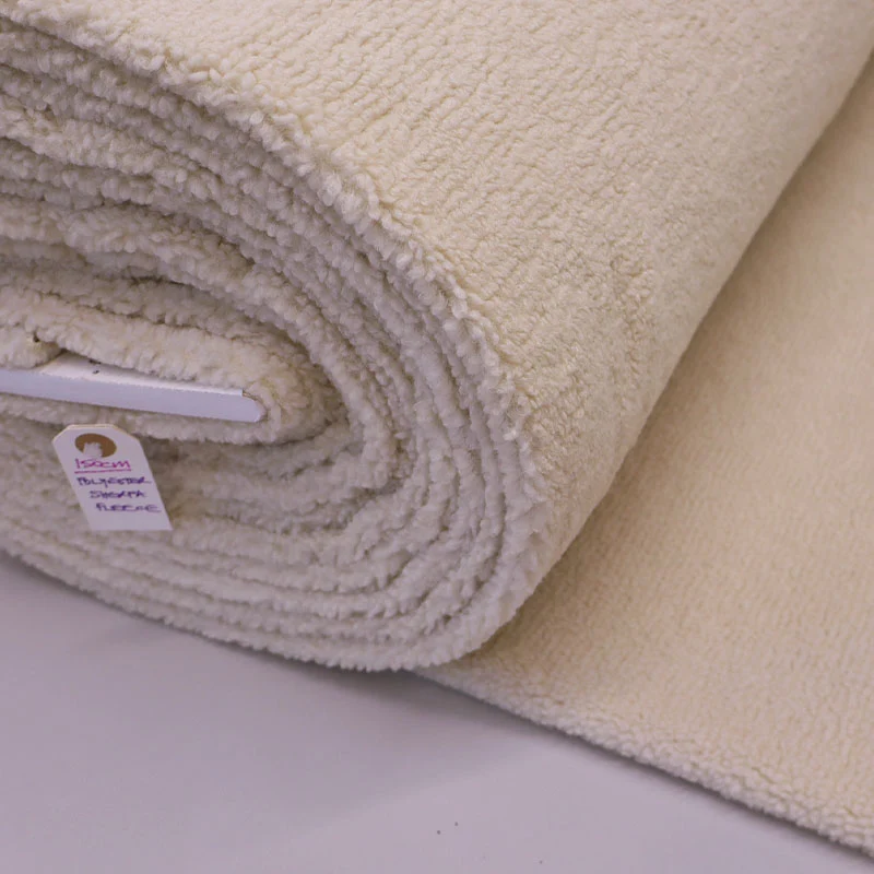 Oatmeal sherpa fleece fabric roll showing the pile across a larger cutting rather than a small hand swatch.