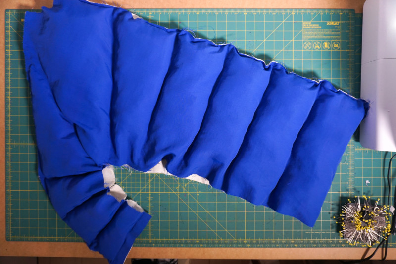 Padded coat construction reference: a blue panel with filled channels before the open edges are closed