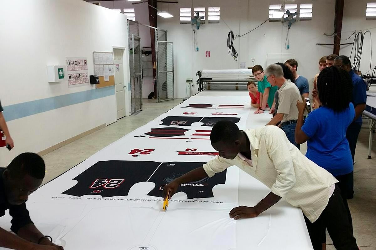 Printed basketball jersey panels being cut on a production table