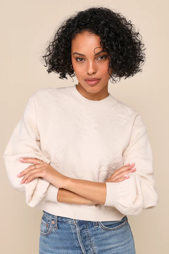 Tonal floral jacquard across a cream pullover.