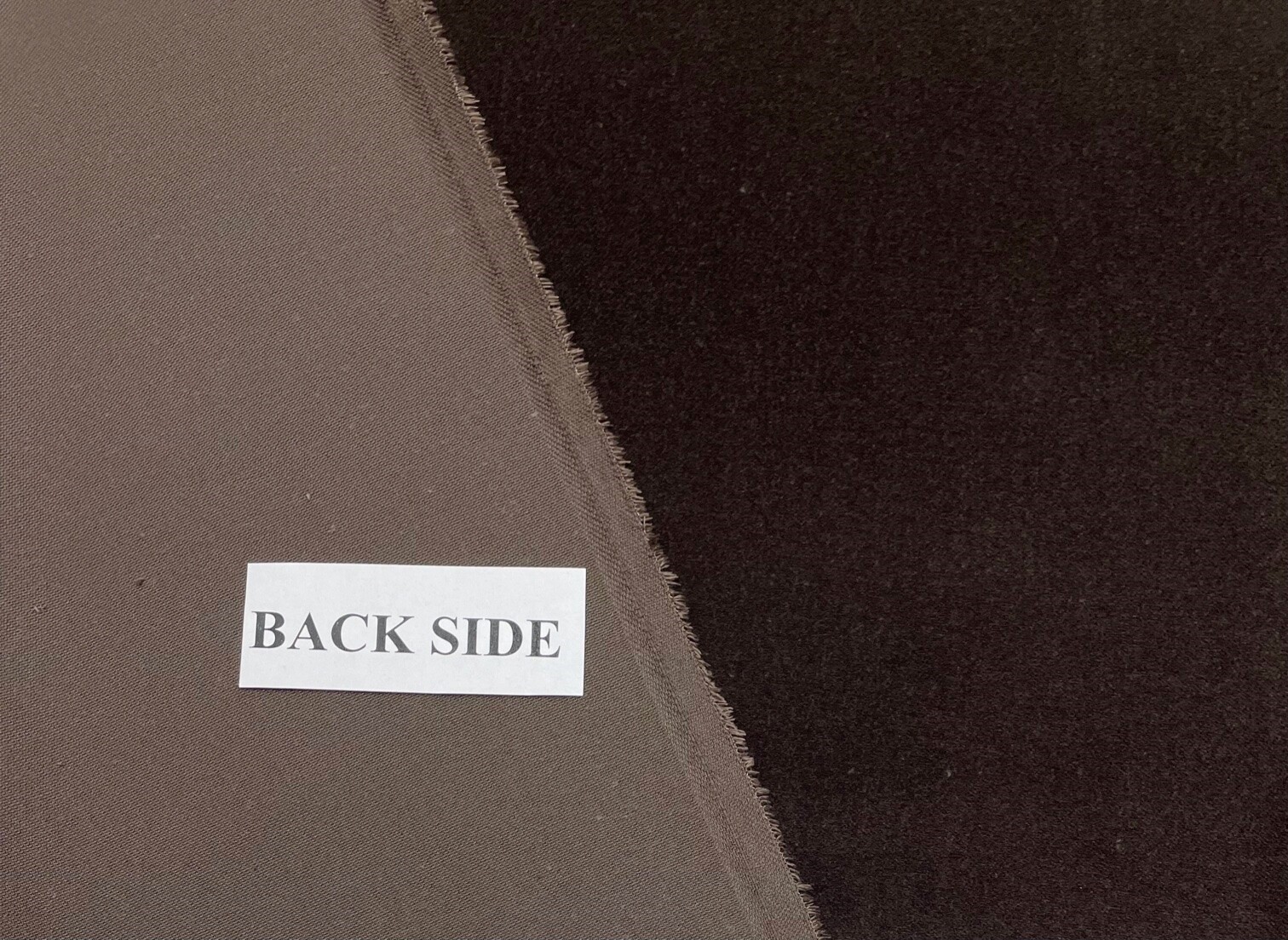 Velvet folded back to show the smooth reverse beside the dark pile face and raw cut edge.