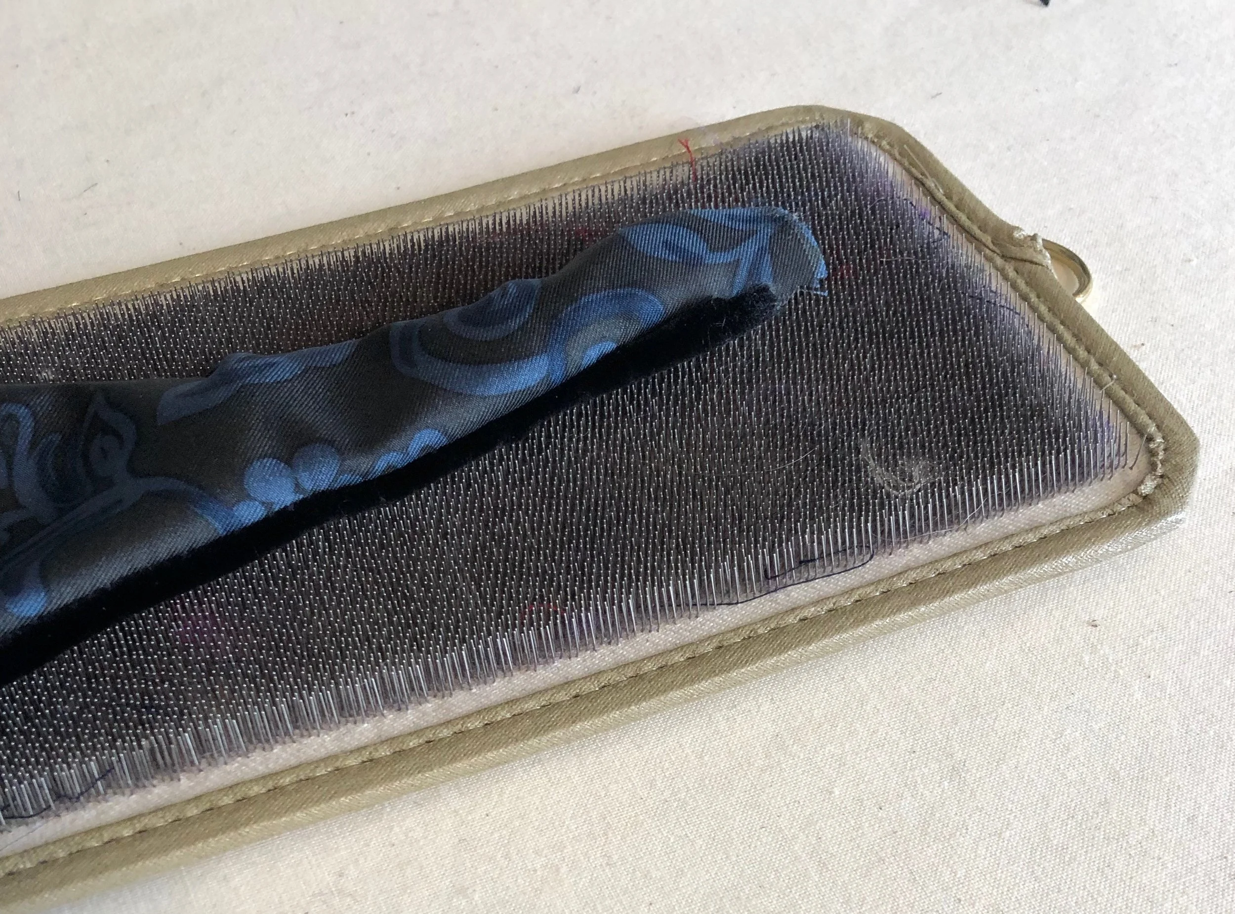 Velvet resting on a needle board that supports the pile during pressing.