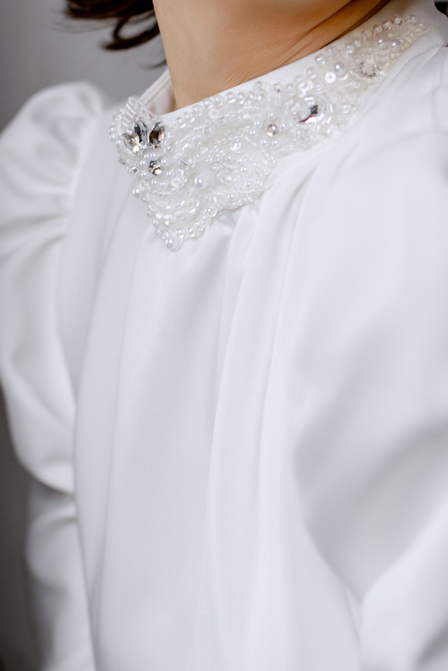 White blouse with a finished embellished collar construction