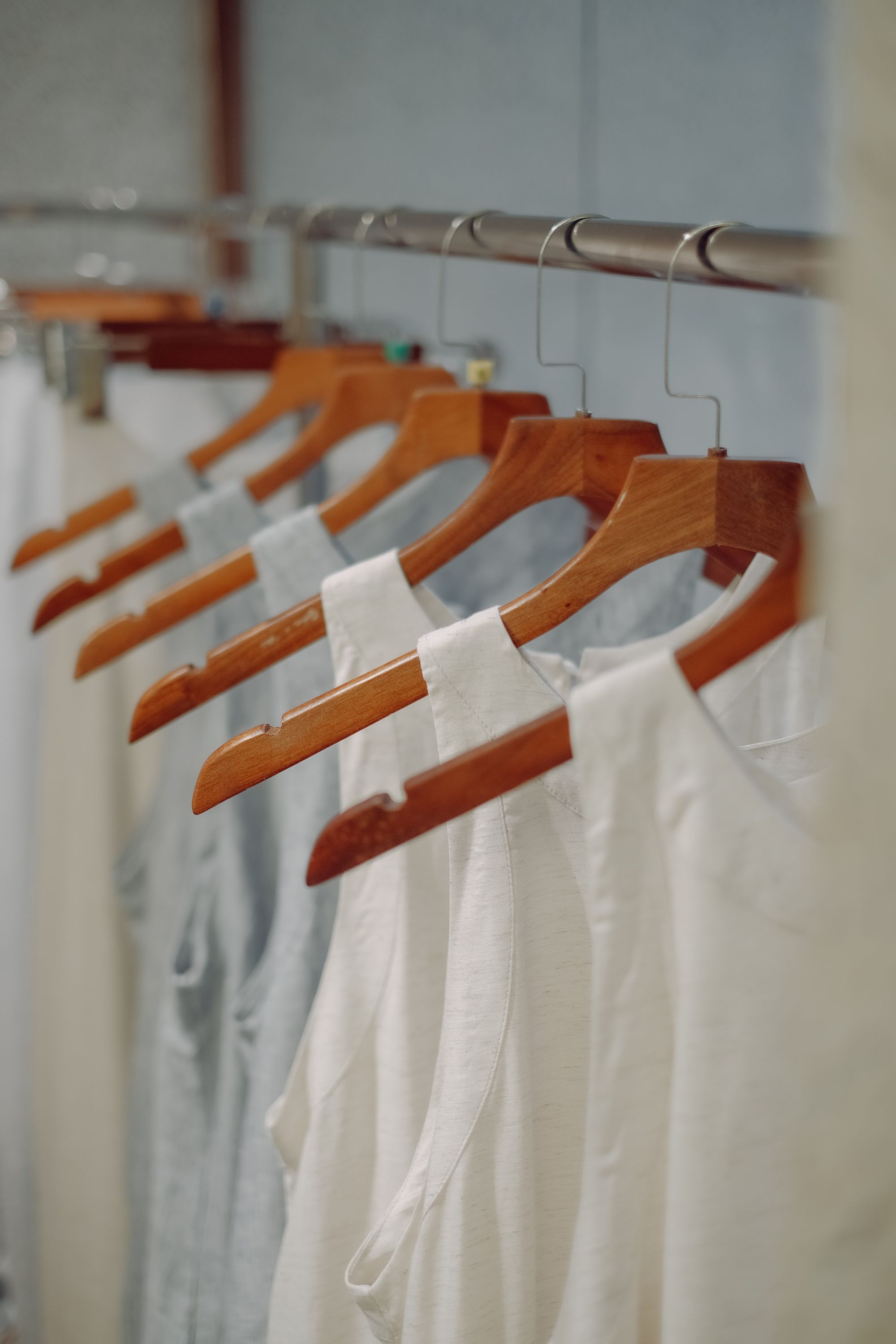 White blouses displayed on wooden hangers with no people in frame