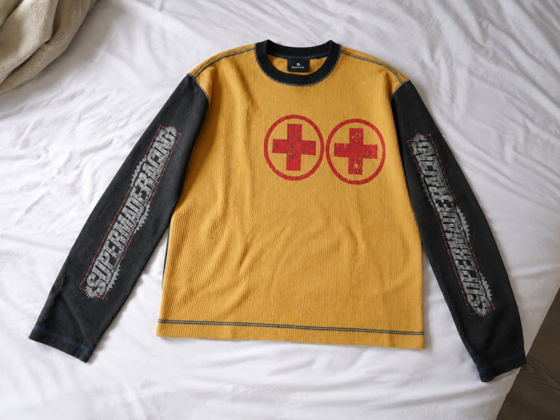 Yellow and black racing-inspired long sleeve laid on white bedding
