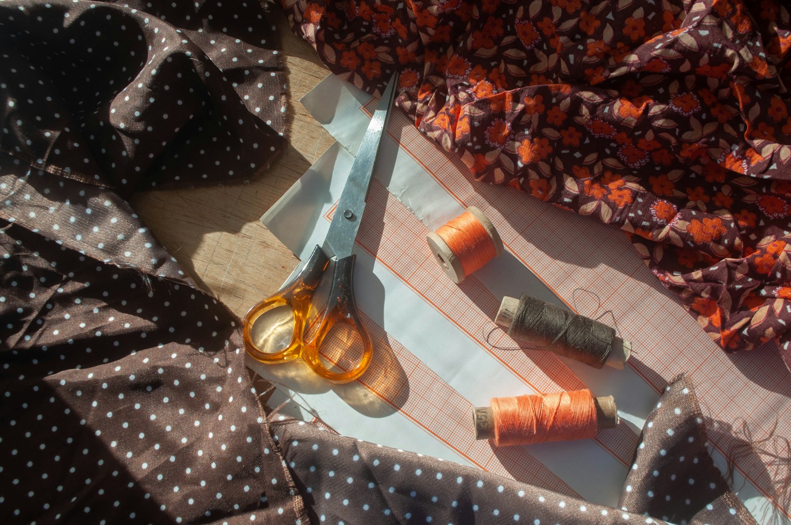 Garment pattern pieces, fabric and sewing tools on a work table