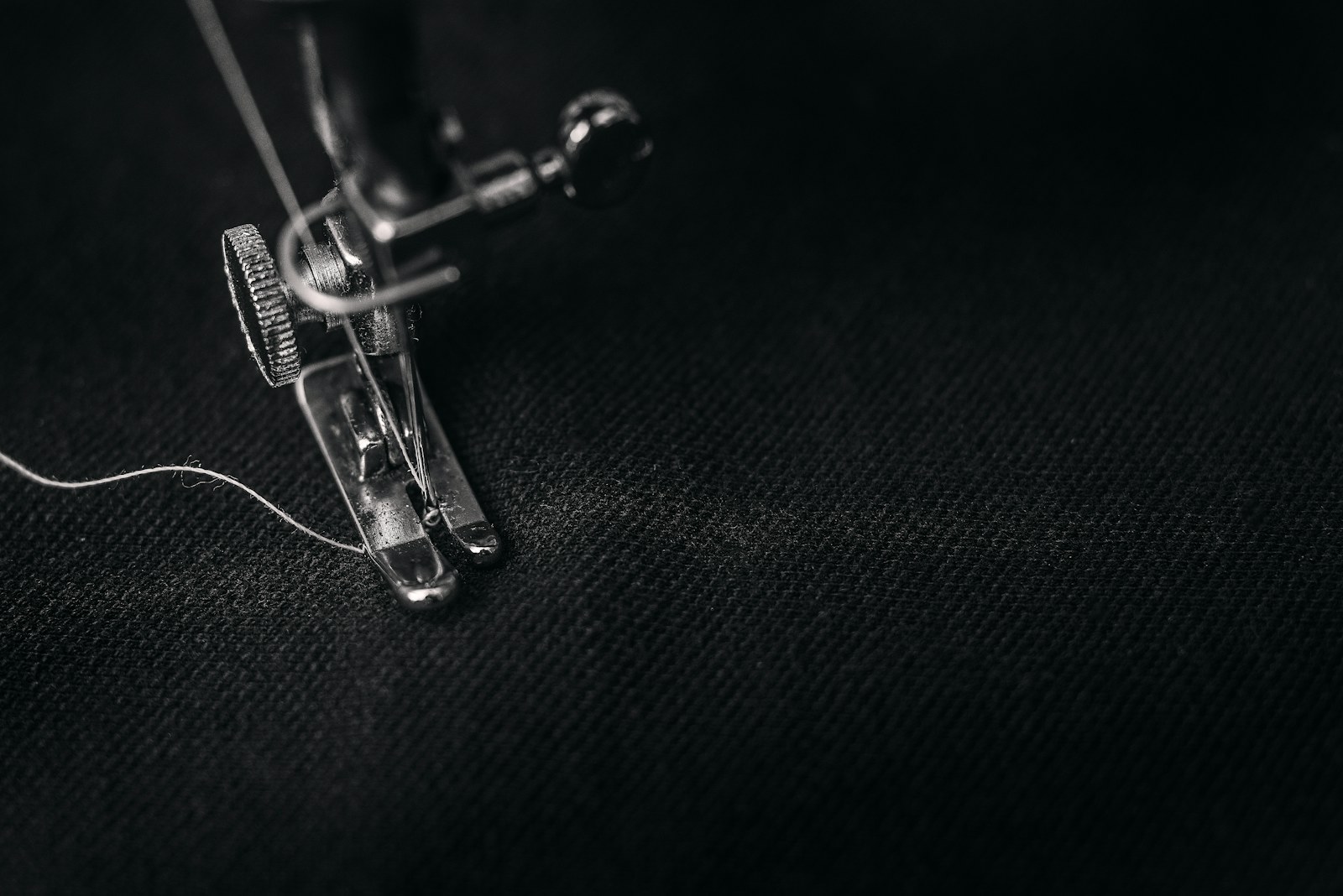Close view of a sewing machine stitching fabric for seam construction