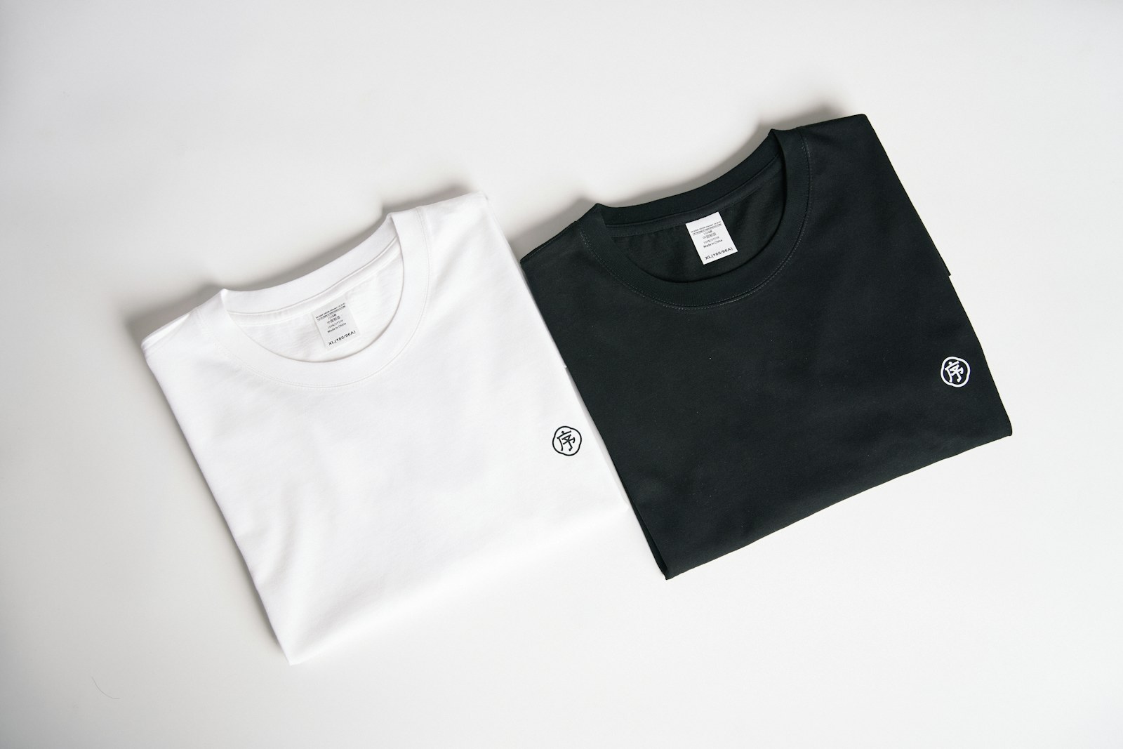 Two plain T-shirts laid flat for comparing garment proportions